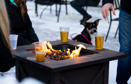 Patrons enjoy Luce Line beers around a fire on the brewery's patio • Photo by Jordan Wipf