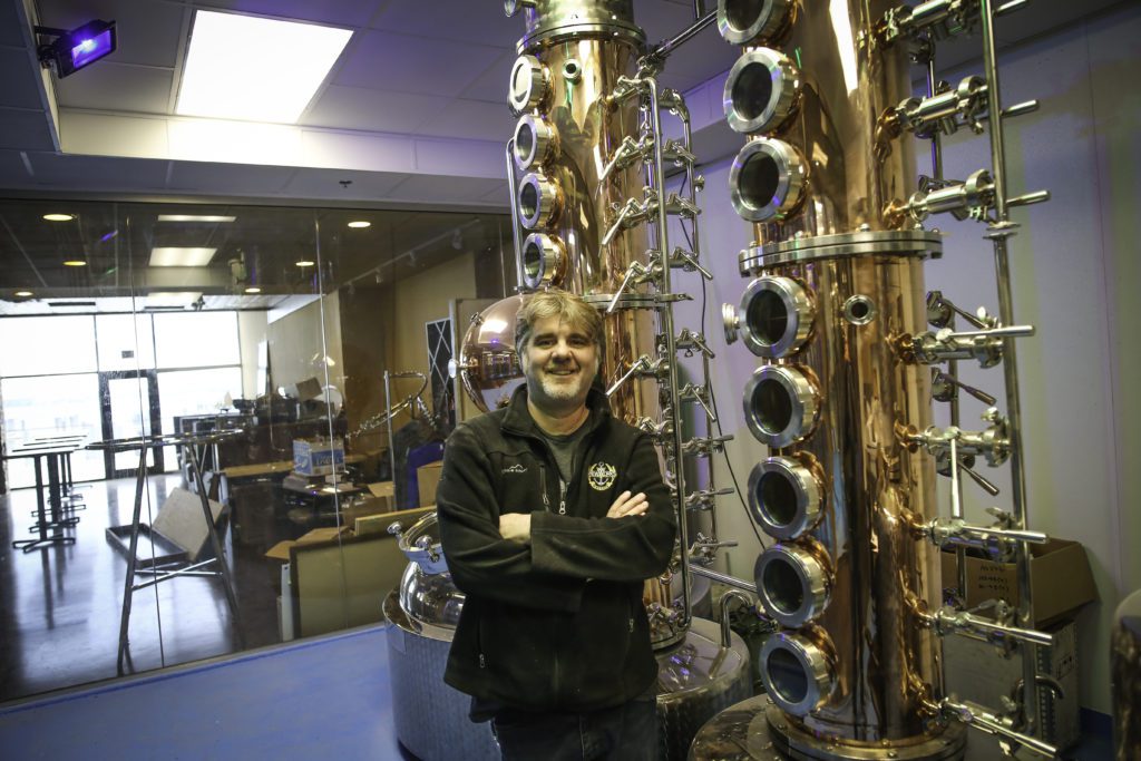 <em> Wayzata Brew Works' Owner Robert Klick poses in front of a piece of distilling equipment. Photo by Aaron Davidson. </em>